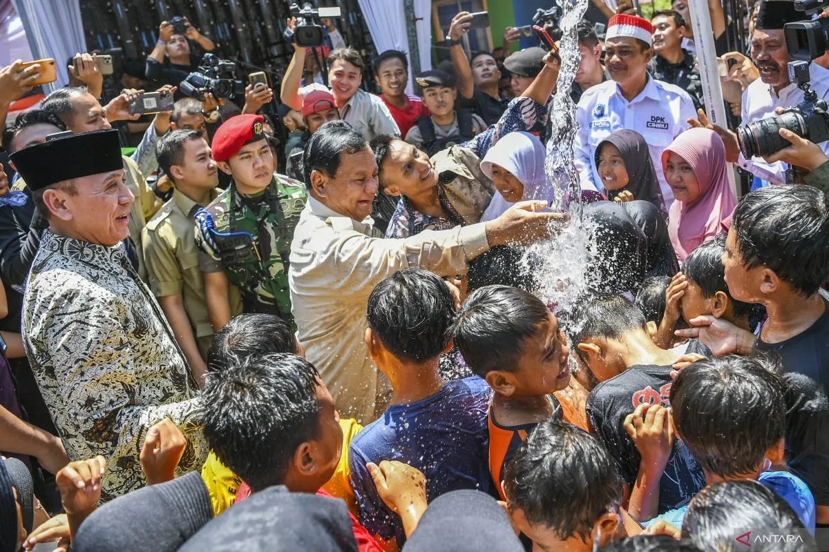 Menteri Pertahanan Prabowo Subianto bermain air bersama anak-anak saat peresmian dan penyerahan proyek bantuan air bersih di Desa Pamupukan, Kabupaten Kuningan, Jawa Barat, Rabu (20/12/2023). (Galih Pradipta/Spt)