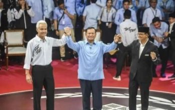 Capres nomor urut 1 Anies Baswedan (kanan), capres nomor urut 2 Prabowo Subianto (tengah), dan capres nomor urut 3 Ganjar Pranowo (kiri) berpegangan tangan usai beradu gagasan dalam debat pertama capres Pemilu 2024 di Gedung KPU RI, Jakarta, Selasa (12/12/2023). (Galih Pradipta)