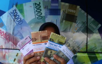 Warga menunjukan uang hasil penukaran di mobil kas keliling Bank Indonesia. (Andri Saputra)
