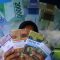 Warga menunjukan uang hasil penukaran di mobil kas keliling Bank Indonesia. (Andri Saputra)