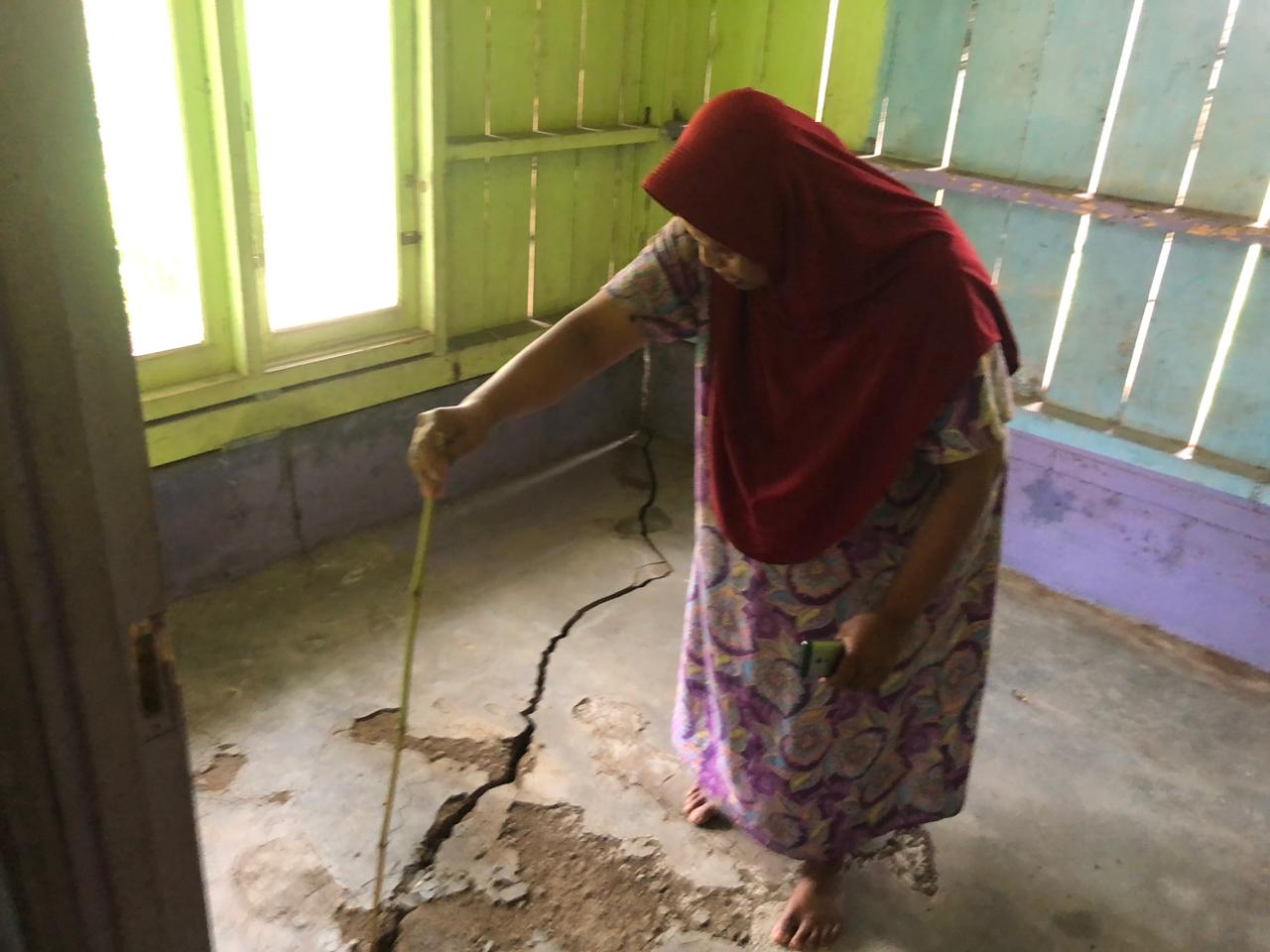 TERDAMPAK : Seorang warga Kampung Jati, RT (05/04) Desa Mekarsari, Kecamatan Nyalindung, Tini (53) saat menunjukan rumahnya yang terdampak retakan tanah.(FOTO : DENDI/RADAR SUKABUMI) 