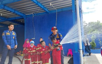 MENGENAL PROFESI: Salah satu petugas Damkar Sektor Parungkuda sedang memperagakan cara menanggulangi kebakaran kepada siswa-siswi TK. (dok/radarsukabumi)
