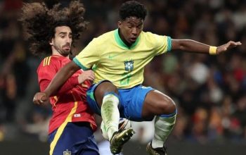 Pemain depan Brasil Endrick (kanan) melompat untuk mengejar bola di samping bek Spanyol Cucurella pada laga persahabatan internasional antara Spanyol dan Brasil di stadion Santiago Bernabeu di Madrid, Spanyol (26/3/2024). (AFP/Thomas COEX)