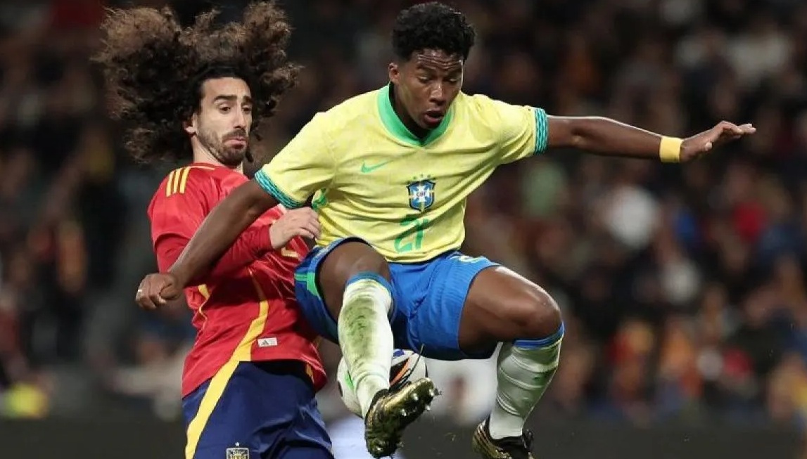 Pemain depan Brasil Endrick (kanan) melompat untuk mengejar bola di samping bek Spanyol Cucurella pada laga persahabatan internasional antara Spanyol dan Brasil di stadion Santiago Bernabeu di Madrid, Spanyol (26/3/2024). (AFP/Thomas COEX)