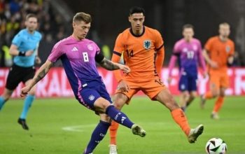 Gelandang Jerman Toni Kroos dibayangi pemain Belanda Tijjanu Reijnders dalam pertandingan persahabatan di Deutsche Bank Park, Frankfurt, Jerman, Rabu (27/3/2024). (AFP/Kirill Kudryavtsev)