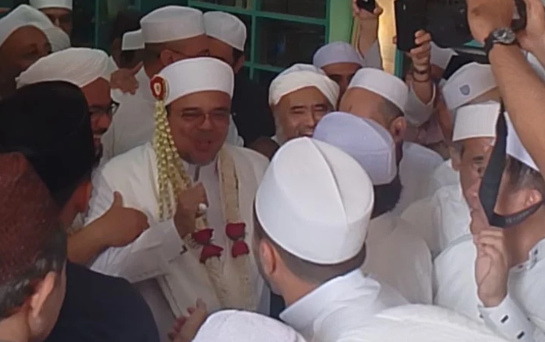 Terlihat Habib Rizieq Shihab mengenakan gamis serba putih yang ditambah rangkaian bunga melati dan mawar pada penutup kepala Habib Rizieq Shihab.-Tangkapan layar-