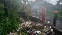 EVAKUASI: Sejumlah petigas saat mengevakuasi bajir limpasan di Jalan Kabandungan, Kematan Gunungpuyuh, Minggu (24/3).