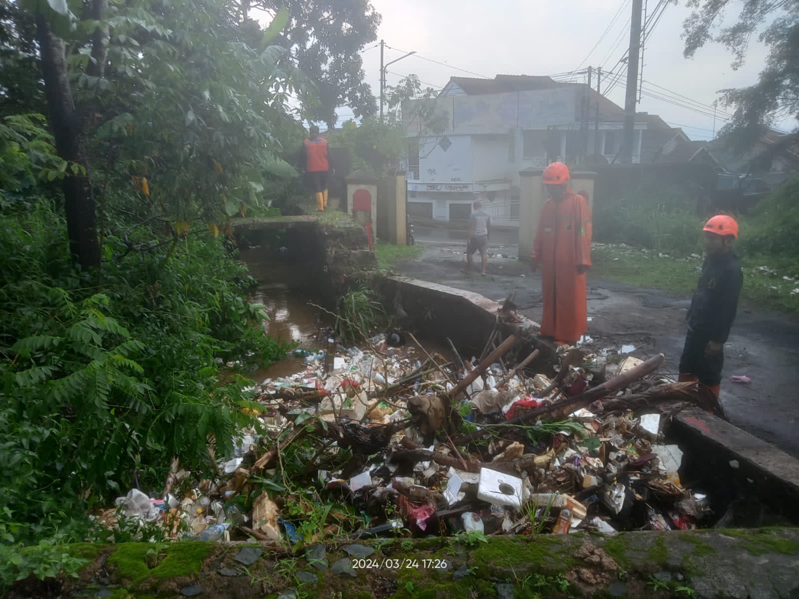 EVAKUASI: Sejumlah petigas saat mengevakuasi bajir limpasan di Jalan Kabandungan, Kematan Gunungpuyuh, Minggu (24/3).