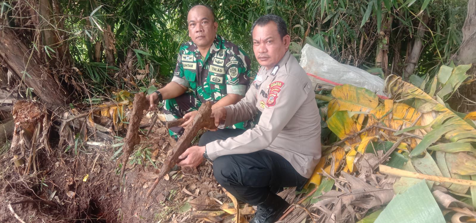 DIAMANKAN : Babinsa dan Bhabinkamtibmas saat mengamankan senjata laras panjang yang ditemukan dalam tanah di Kampung Cimahi, RT 02/RW 01, Desa Selajambe, Kecamatan Cisaat, Kabupaten Sukabumi.(Foto :ist)
