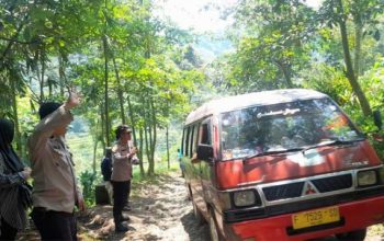 TERJEBAK : Polisi saat membantu mobil pemudik yang terperangkap masuk jalur alternatif Ciambar - Nagrak, Kabupaten Sukabumi pada Selasa (25/04).