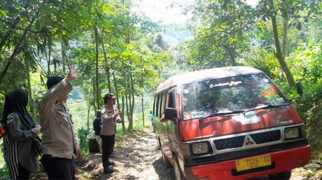 TERJEBAK : Polisi saat membantu mobil pemudik yang terperangkap masuk jalur alternatif Ciambar - Nagrak, Kabupaten Sukabumi pada Selasa (25/04).