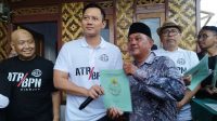 Menteri Agraria dan Tata Ruang/Kepala Badan Pertanahan Nasional (ATR/BPN) Agus Harimurti Yudhoyono atau AHY menyerahkan sertifikat hasil konsolidasi tanah bagi warga Cianjur, Jawa Barat, Minggu (21/4/2024). (Muzdaffar Fauzan)