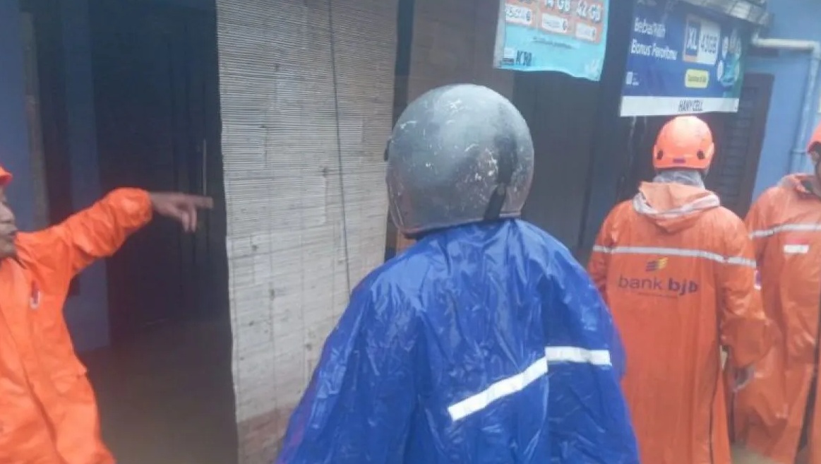 Petugas BPBD Kota Sukabumi saat menanggulangi bencana banjir akibat meluapnya Sungai Ciseupan Situawi yang terjadi di Kampung Situawi, Kelurahan Karangtengah, Kecamatan Gunungpuyuh, Kota Sukabumi, pada Selasa (23/4/2024).