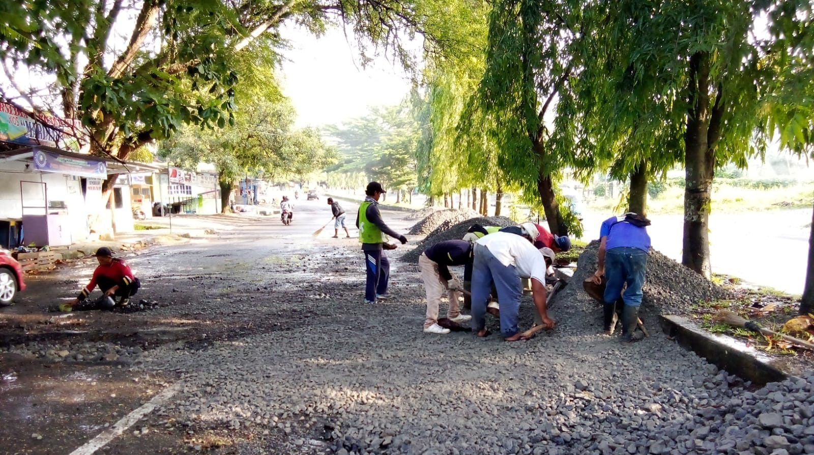 DIPERBAIKI : Sejumlah petugas saat memproses perbaikan jalan rusak di depan Lapang Cangehgar Palabuhanratu tepatnya di jalan Jendral Ahmad Yani.