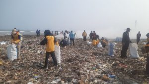 Peserta aksi bersih bersih sampah di pantai Talanca Loji antusias memungut sampah yang berserakan.(FOTO : NANDI/ RADARSUKABUMI)