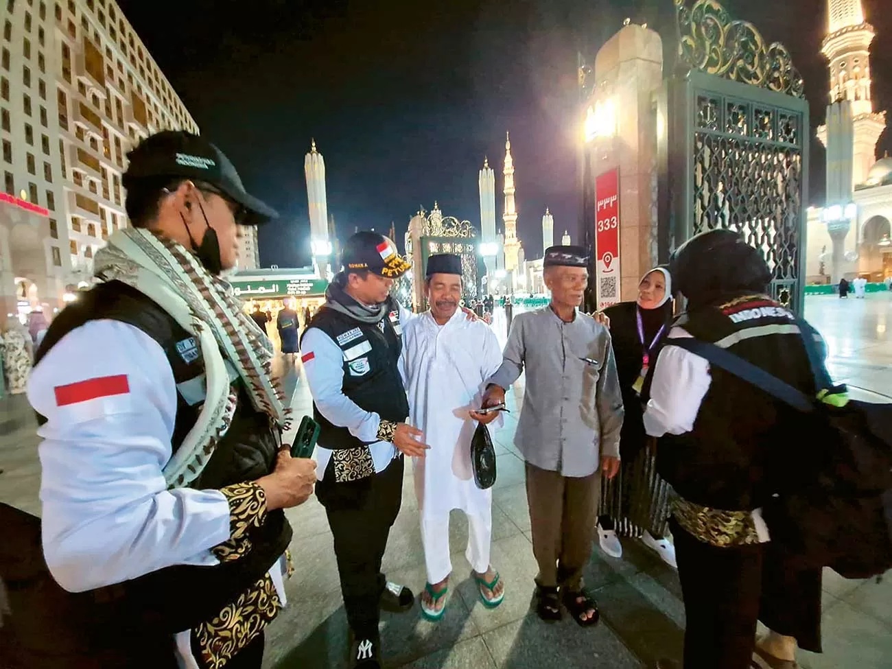 DIANTAR BALIK: Petugas haji mengantar seorang jemaah haji yang sempat kebingungan pulang saat berada di area Masjid Nabawi, Madinah, Kamis (16/5) malam Waktu Arab Saudi. (ARIS IMAM MASYHUDI/JAWA POS)