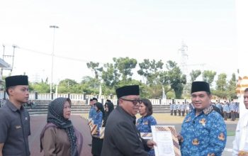 Bupati Sukabumi Marwan Hamami menyerahkan SK pengangkatan PPPK Pemkab Sukabumi formasi 2023 secara simbolis kepada salah satu pegawai saat apel penyerahan SK pengangkatan PPPK kepad 750 pegawai di Lapang Cangehgar, Kecamatan Palabuhanratu, Kabupaten Sukabumi, Jabar pada Rabu (22/5/2024).