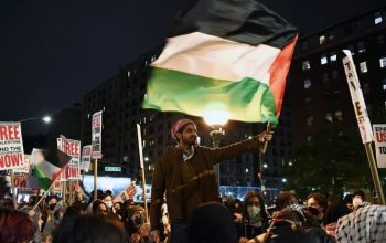 Seorang pria mengibarkan bendera Palestina dalam aksi unjuk rasa pro-Palestina yang digelar di luar Universitas Columbia di New York, Amerika Serikat, Selasa (23/4/2024). Xinhua.