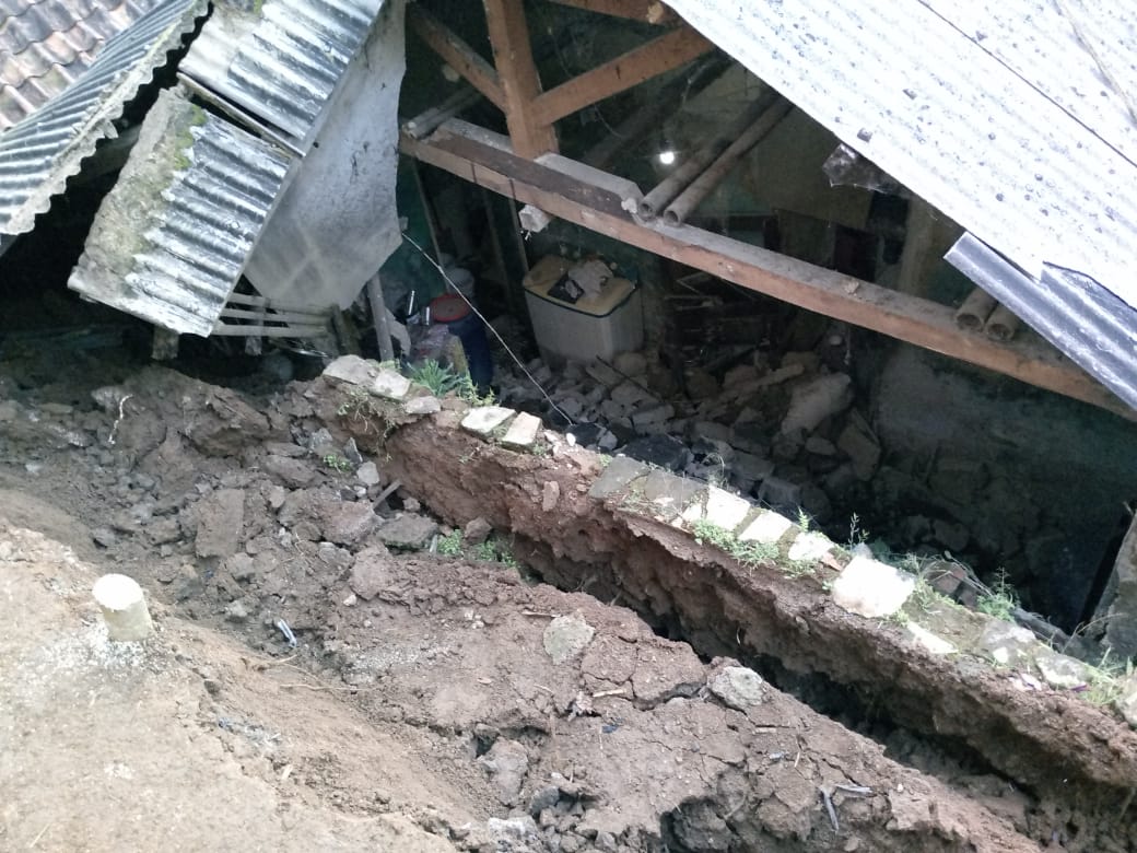 DIBERSIHKAN : Warga saat gotong royong membersihkan material longsor yang menimpa rumah Mak Empat (68) Kampung Pajegan, RT 019/RW 06, Desa Cikembang, Kecamatan Caringin, Kabupaten Sukabumi pada Jumat (10/05).(Foto : ist)