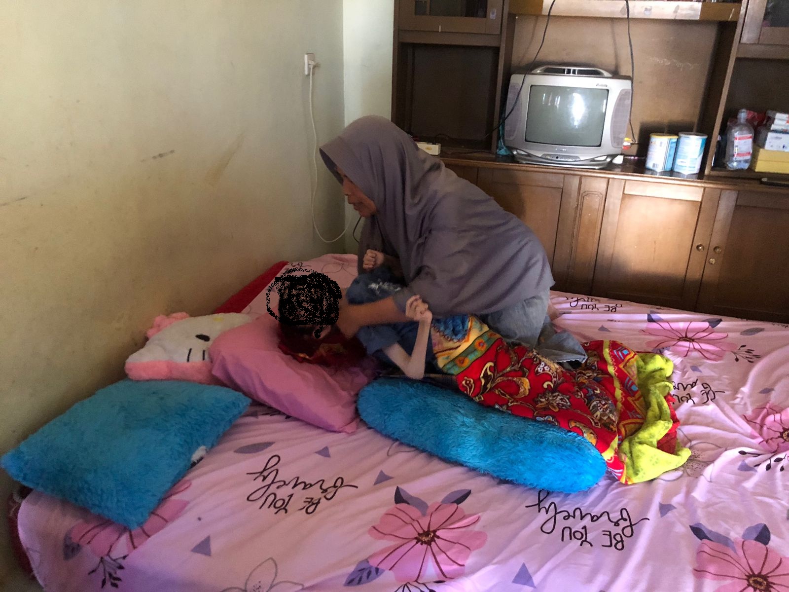 MEMPRIHATINKAN : Ibu Waqiah (55) saat memeluk anak bungsunya, Abdurahman (17) asal warga Kampung Lemah Duhur, RT 02/RW 11, Desa Margaluyu, Kecamatan Sukaraja, Kabupaten Sukabumi yang mengidap penyakit cerebral palsy, sejak lahir.(FOTO : DENDI/RADAR SUKABUMI)