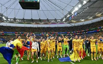 Para pemain dan staf Rumania merayakan kemenangan grup mereka di lapangan setelah pertandingan sepak bola Grup E UEFA Euro 2024 antara Slovakia dan Rumania di Frankfurt Arena di Frankfurt am Main pada 26 Juni 2024. (AFP/Javier Soriano)