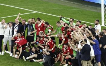 Para pemain Georgia merayakan keberhasilan mereka lolos ke fase gugur Euro 2024 setelah menumbangkan Portugal 2-0 dalam pertandingan Grup F di Arena AufSchalke di Gelsenkirchen pada 26 Juni 2024. (AFP/Kenzo Triboollard)