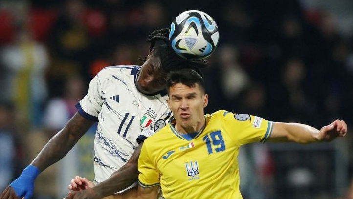 Pesepak bola Ukraina Oleksandr Tymchyk (kanan) berebut bola dengan pesepak bola Italia Moise Kean dalam pertandingan Grup C kualifikasi Piala Eropa 2024 di Stadion BayArena, Leverkusen, Jerman (20/11/2023). Pertandingan berakhir imbang 0-0. (REUTERS/Thilo Schmuelgen)