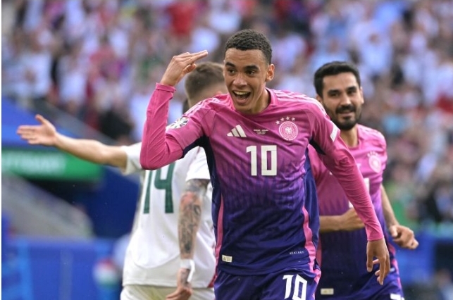 Germany's midfielder Jamal Musiala (C) celebrates after scoring the opening goal during the UEFA Euro 2024 Group A football match between Germany and Hungary at the Stuttgart Arena in Stuttgart on June 19, 2024. (Photo by DAMIEN MEYER / AFP) 