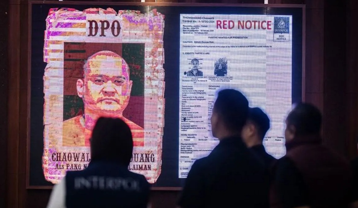 Seorang polisi berada didekat layar yang menampilkan gambar buronan Interpol Thailand Chaowalit Thongduang saat konferensi pers penangkapan buronan Interpol Thailand di Gedung Bareskrim Polri, Jakarta, Minggu (2/6/2024).