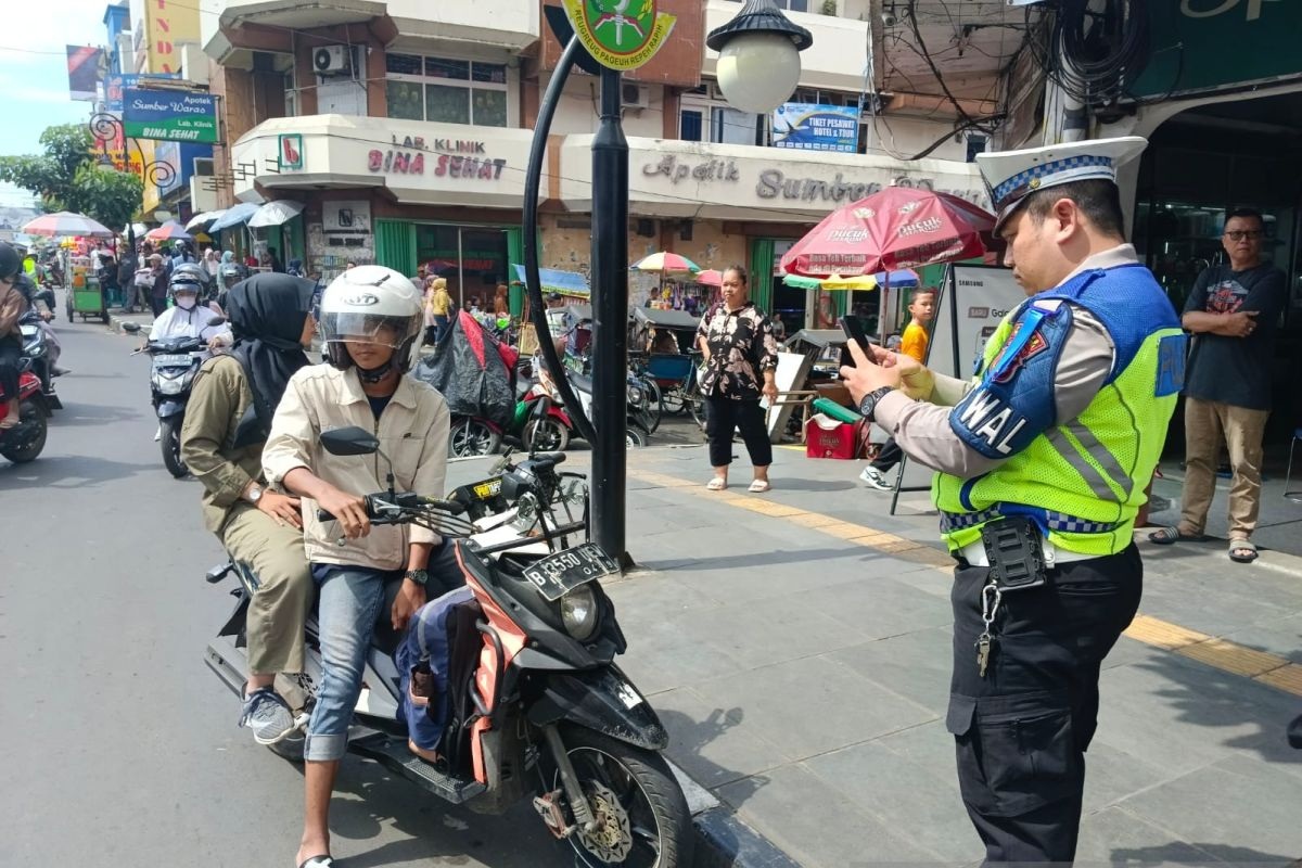Petugas Satlantas Polres Sukabumi Kota saat menegur pengendara sepeda motor yang tidak mengenakan helm.