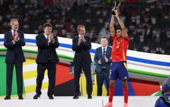 Rodri mengangkat trofi Pemain Terbaik Euro 2024 setelah laga final Spanyol melawan Inggris di Olympiastadion, Berlin, Jerman, 14 Jili 2024. (AFP/ADRIAN DENNIS)