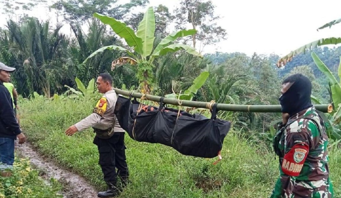 Personel Bhabinkamtibmas Polsek Cisolok dan Babinsa Koramil Cisolok saat mengevakuasi jenazah tanpa identitas yang ditemukan warga tersangkut di bebatuan Sungai Cibareno tepatnya di Kampung Cireundeu, Desa Caringin, Kecamatan Cisolok, Kabupaten Sukabumi, Jabar pada Jumat (5/7/2024).