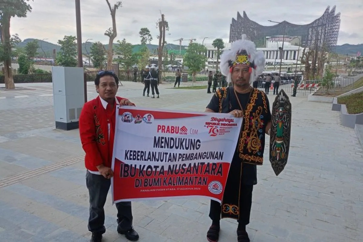 Warga Sampit Kalimantan Tengah Wahyudi (kiri) bersama dengan pekerja kemenko 1 IKN Dewo di depan Istana Negara IKN, Sabtu (17/8/2024). (Rangga Pandu Asmara Jingga)