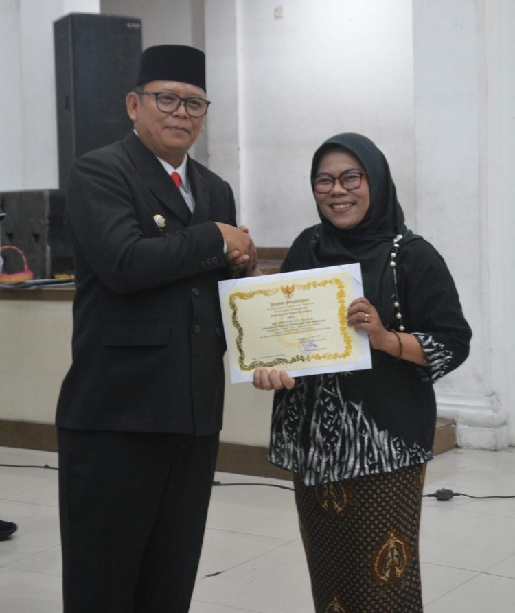 KEREN: Pj Wali Kota Sukabumi, Kusmana Hartadji menyerahkan langsung penghargaan kepada Penyiar Terfavorit Jabar 2023, Mbak Tyas pada acara Penganugerahan Tanda Kehormatan Satya Lancana Karya Satya Presiden Republik Indonesia, Satya Lancana Sosial dan Piagam Penghargaan kepada Pegawai dan Masyarakat di Lingkungan Pemerintah Kota Sukabumi 2024 yang digagas BKPSDM Kota Sukabumi di Gedung Juang 45 Kota Sukabumi, Kamis (15/8/2024).(ist)