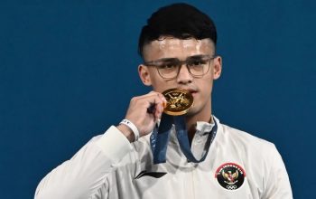Lifter Indonesia Rizki Juniansyah berpose dengan medali emasnya usai upacara pengalungan medali kelas 73 kg putra Olimpiade Paris 2024 di South Paris Arena, Paris, Prancis, Kamis (8/8/2024).  (ANTARA FOTO/Wahyu Putro A/pras)