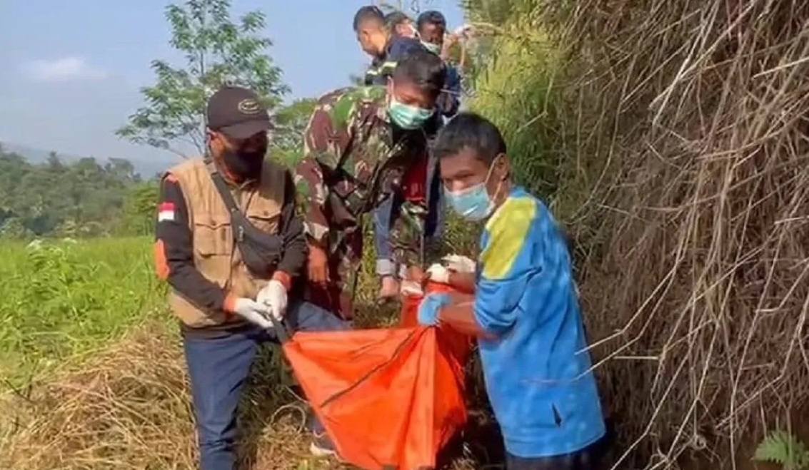 Petugas gabungan dari unsur TNI dan Polri yang dibantu masyarakat saat mengevakuasi jasad pria tanpa identitas yang ditemukan di aliran irigrasi di Kampung Cimanggu, RT 01/06, Desa Ciheulangtonggoh, Kecamatan Cibadak, Kabupaten Sukabumi, Jabar, Sabtu (31/8/2024). (Aditya Rohman)