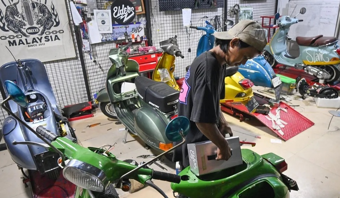 Teknisi mengkonversi sepeda motor berbahan bakar minyak menjadi sepeda motor listrik di Bengkel Elders Garage, Pancoran, Jakarta, Jumat (2/8/2024). (Aditya Pradana Putra)
