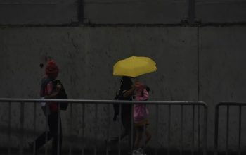 Pejalan kaki menggunakan payung untuk berlindung dari hujan saat melintas di pedestrian MRT Lebak Bulus, Jakarta Selatan, Jumat (1/12/2023).