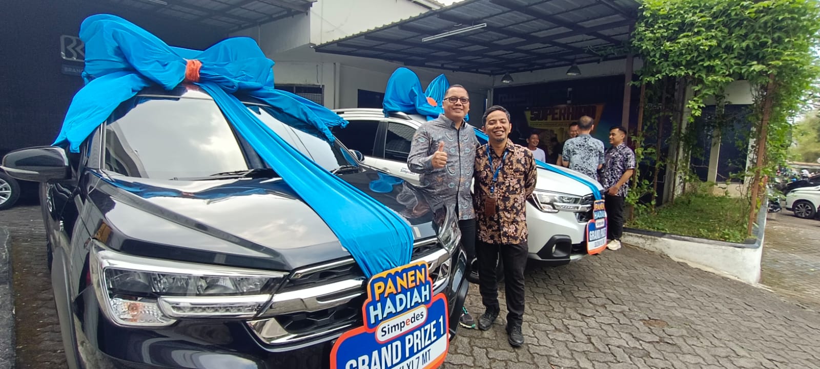 HADIAH GRATIS: Pinca BRI Sukabumi, Duta Okki Wicaksono didampingi Ketua Panitia PHS Periode II/2023 sekaligus Kaunit BRI Sukalarang, Irwan Maulana tersenyum bahagia diantara dua mobil hadiah grand prize PHS di halaman BRI BO Sukabumi, Selasa (10/9/2024). (sri/radarsukabumi)