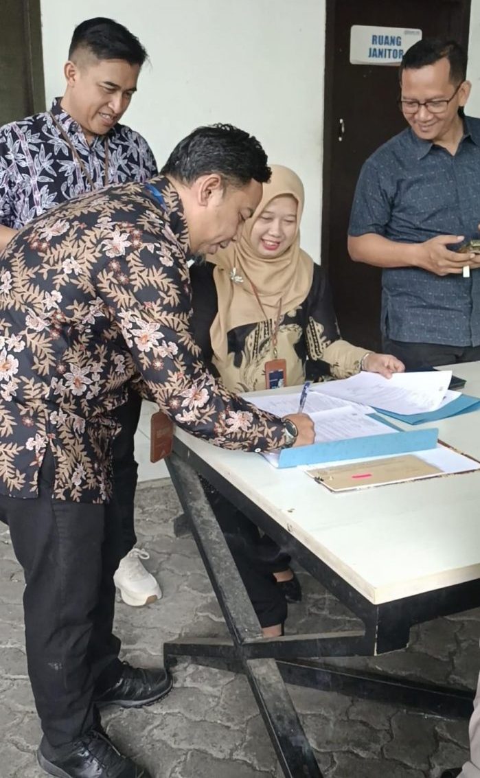 TANDATANGAN BERKAS: Ketua Panitia PHS Periode II/2023 sekaligus Kaunit BRI Sukalarang, Irwan Maulana menandatangani berkas penyerahan hadiah mobil undian Panen Hadiah Simpedes dihadapan para kepala unit yang nasabahnya menjadi pemenang di halaman BRI BO Sukabumi, Selasa (10/2). (sri)