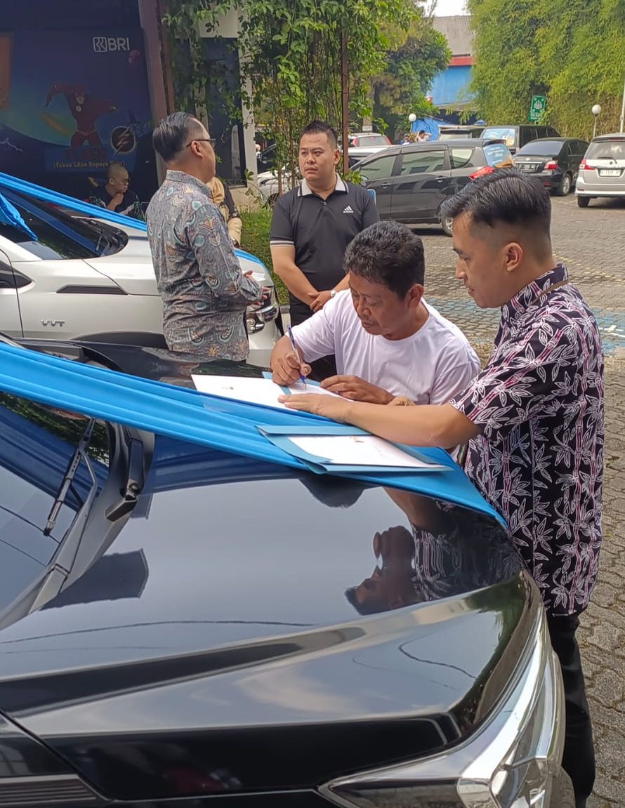SERAH TERIMA HADIAH: Nasabah BRI Unit Cisaat Sukabumi, Suhenda bersama Kaunit BRI Cisaat Irfan Abdul Rohman menandatangani berkas penyerahan hadiah grand prize PHS berupa mobil. (sri/radarsukabumi)