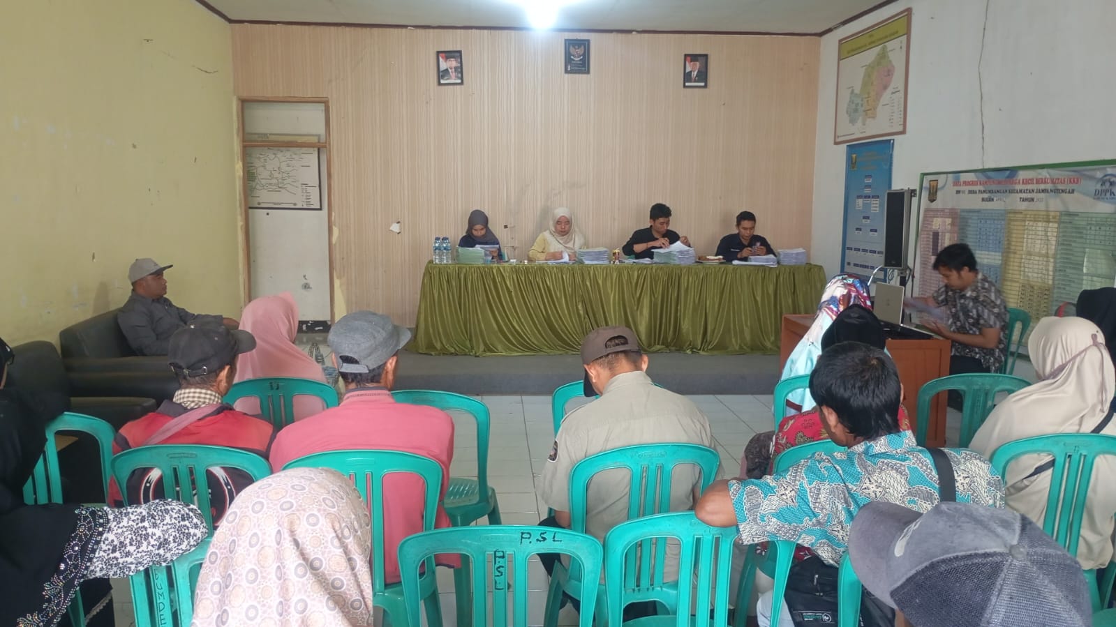 SIMBOLIS : Petugas Kantah Kabupaten Sukabumi, saat menyerahkan sertipikat PTSL kepada warga di kantor aula Desa Panumbangan, Kecamatan Jampangtengah, Kabupaten Sukabumi.(FOTO : UNTUK RADAR SUKABUMI)