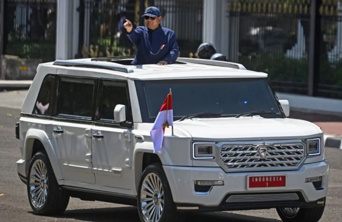 Presiden Prabowo Subianto berdiri menyapa warga dari mobil Pindad Maung Garuda saat tiba di Istana Merdeka, Jakarta, Minggu (20/10/2024).