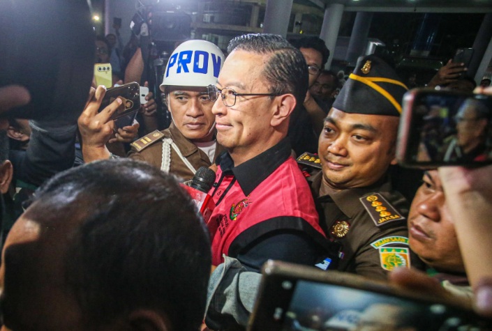 Menteri Perdagangan tahun 2015-2016 Thomas Lembong dibawa menuju mobil tahanan di Kejaksaan Agung, Jakarta, Selasa (29/10/2024). (Miftahul Hayat/ Jawa Pos)