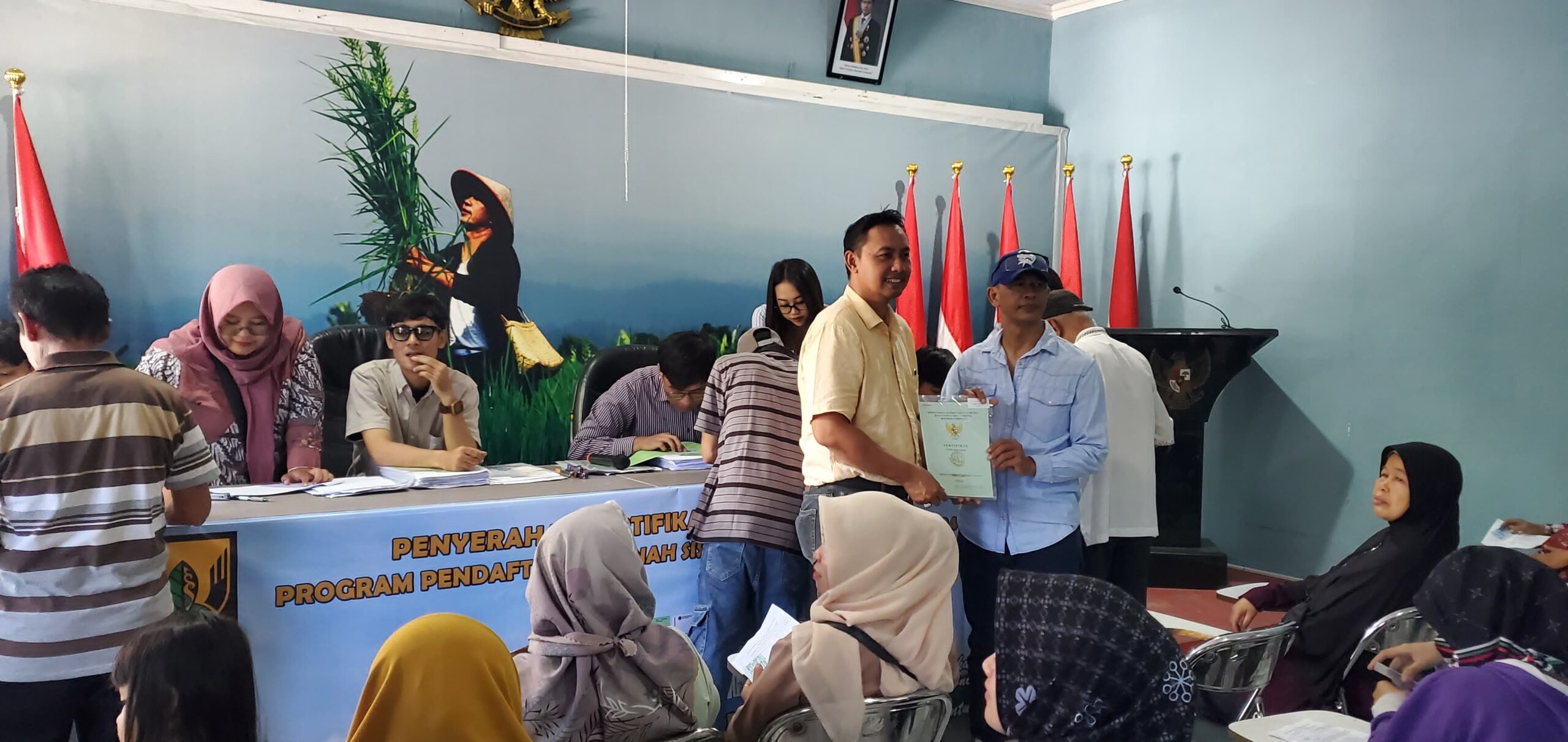 DIBERIKAN : Petugas Kantah Kabupaten Sukabumi, saat menyerahkan sertifikat tanah di kantor Desa Desa Pasawahan, Kecamatan Cicurug, Kabupaten Sukabumi.(FOTO : UNTUK RADAR SUKABUMI)
