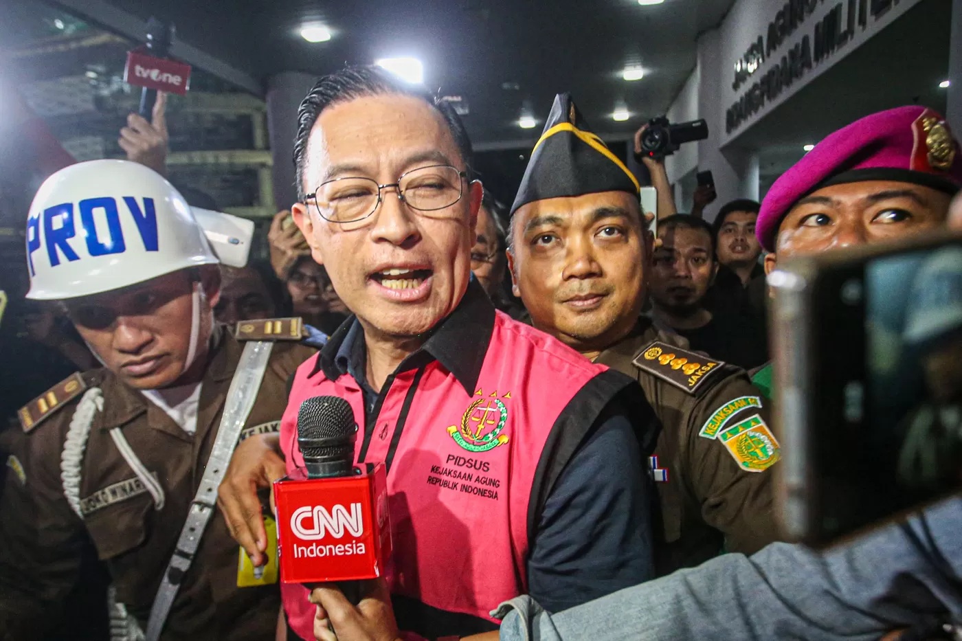 Menteri Perdagangan tahun 2015-2016 Thomas Lembong dibawa menuju mobil tahanan di Kejaksaan Agung, Jakarta, Selasa (29/10/2024). (Miftahul Hayat/Jawa Pos)