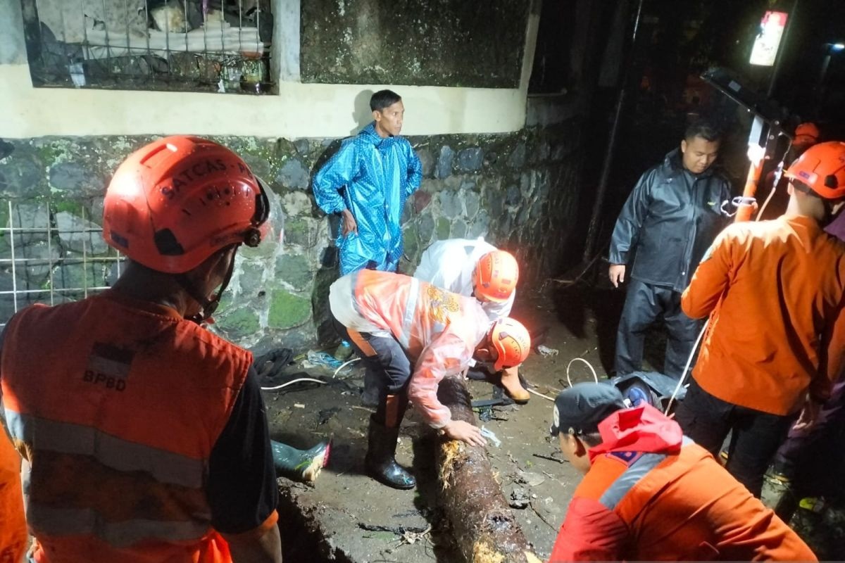 Petugas BPBD Kota Sukabumi saat melakukan normalisasi saluran air yang tersumbat sampah sehingga menjadi pemicu terjadinya banjir yang mengakibatkan ruang kelas SMKN 1 Kota Sukabumi dan puluhan rumah di Jalan Kabandungan, Kelurahan Selabatu, Kecamatan Cikole, Kota Sukabumi, Jabar terendam banjir pada Jumat, (22/11/2024) malam. (BPBD Kota Sukabumi)