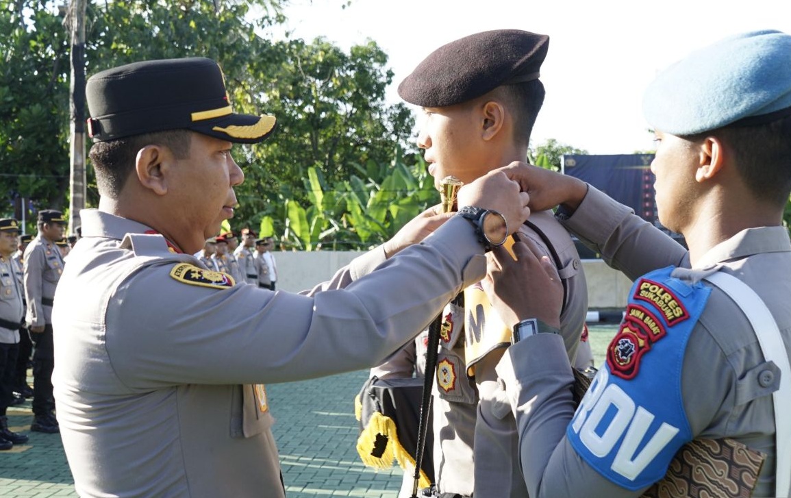 Kapolres Sukabumi AKBP Samian saat menyematkan pita kepada personel Polres Sukabumi yang ditugaskan untuk mengamankan tps Pilkada 2024 saat apel pergeseran pasukan Satgas Operasi Mantap Praja 2024 halaman Mapolres Sukabumi, Kecamatan Palabuhanratu, Kabupaten Sukabumi, Jabar pada Senin, (25/11/2024).
