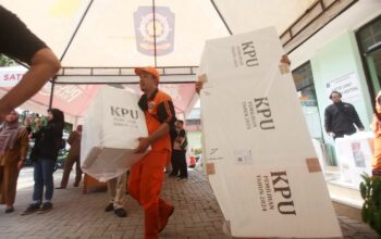Petugas PPSU mengangkat kotak suara berisi logistik Pilkada 2024 untuk didistribuskian ke TPS-TPS Kawasan Menteng, Jakarta Pusat, Selasa (26/11/2024). (Dery Ridwansah/ JawaPos.com)