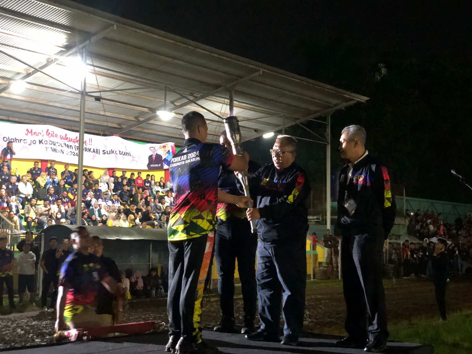 OPENING CEREMONY : Bupati Sukabumi, Marwan Hamami, didampingi Ketua Koni Kabupaten Sukabumi, Sirojudin dan Wakil Ketua III Koni Provinsi Jawa Barat, Kolonel Gunaryo, saat menerima api obor Porkab untuk opening ceremony di Stadion Korpri Cisaat, Komplek Gelanggang Pemuda Cisaat, Kabupaten Sukabumi pada Minggu (15/12) malam. (FOTO : DENDI/RADAR SUKABUMI)